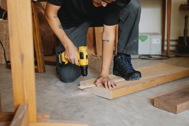 construction worker drilling into a piece of wood